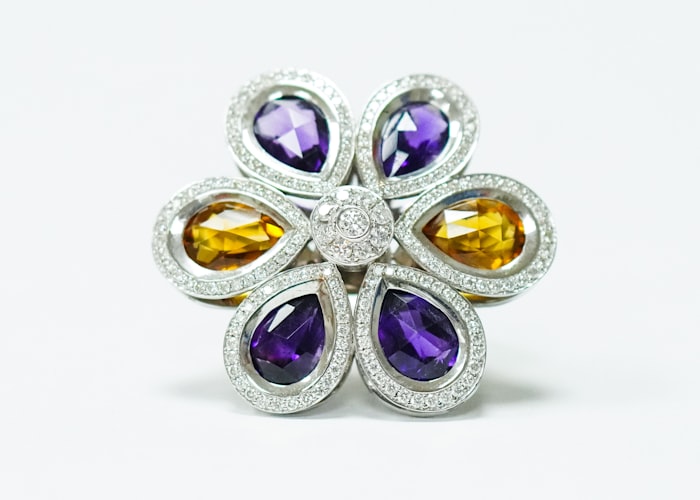 Multi-gemstone floral brooch on white, illustrating a 3D jewellery viewer integration