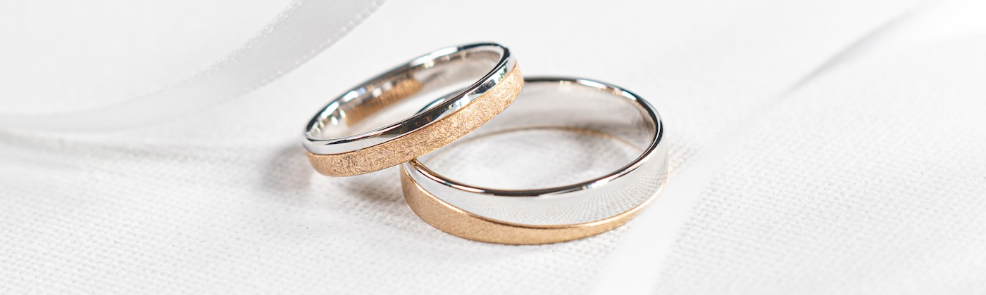 Gold and platinum wedding rings on silk — jewellery website designer in Pune, Maharashtra