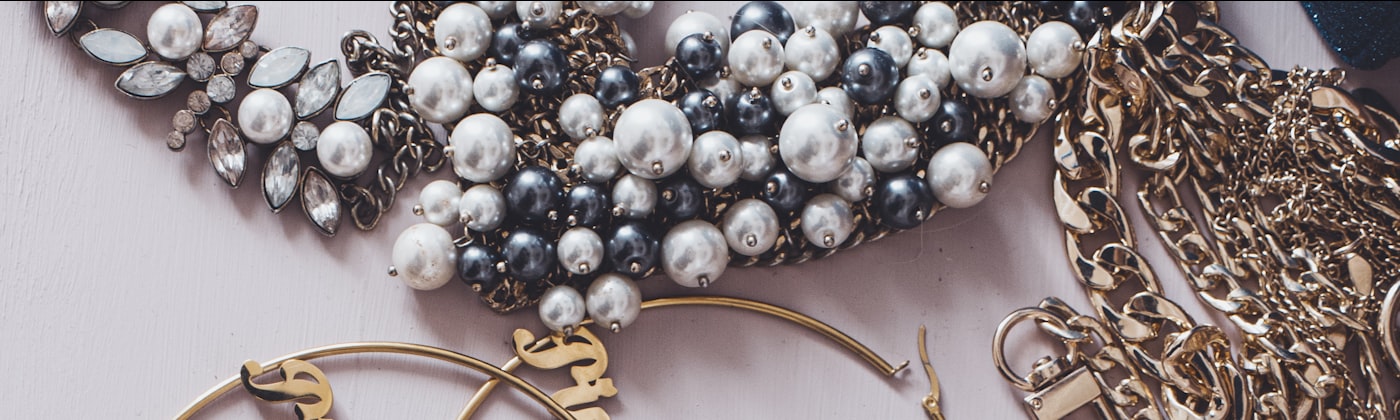 Flat-lay of gold chains, earrings and pendants arranged for a jewellery collection page