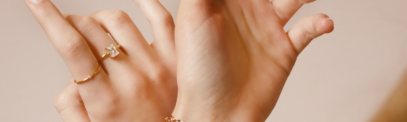 Fine gold bracelets and rings worn on a model, illustrating AR virtual try-on for jewellery websites