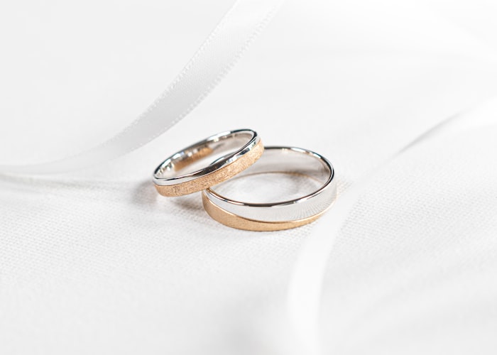 Gold and platinum wedding bands on silk — custom ring builder website development