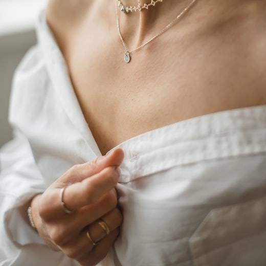 Model wearing layered gold necklaces in a lifestyle jewellery photograph