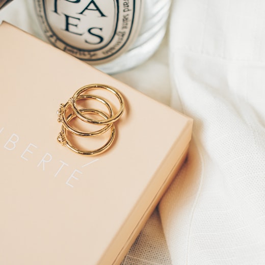 Gold rings resting on a branded jewellery packaging box
